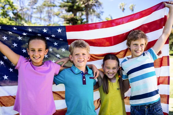 Crianças segurando bandeira americana no parque — Fotografia de Stock