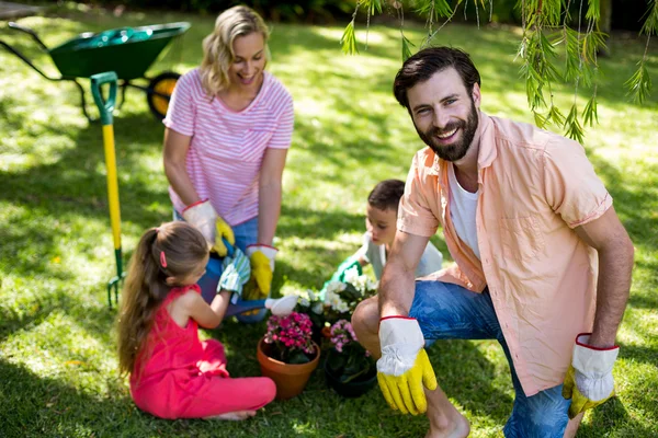 Vater bei Gartenarbeit gegen Familie — Stockfoto