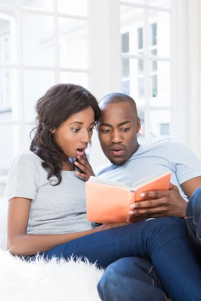 Pareja joven leyendo libro — Foto de Stock