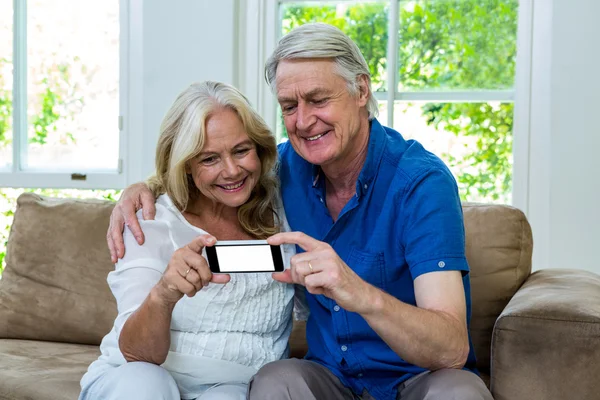 Ηλικιωμένο ζευγάρι που χρησιμοποιεί κινητό τηλέφωνο — Φωτογραφία Αρχείου