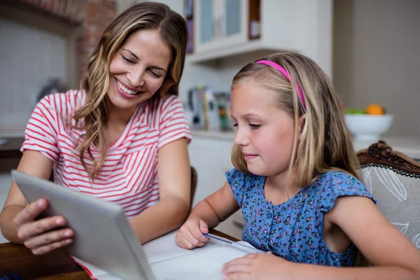 Moeder helpen dochter met huiswerk thuis — Stockfoto