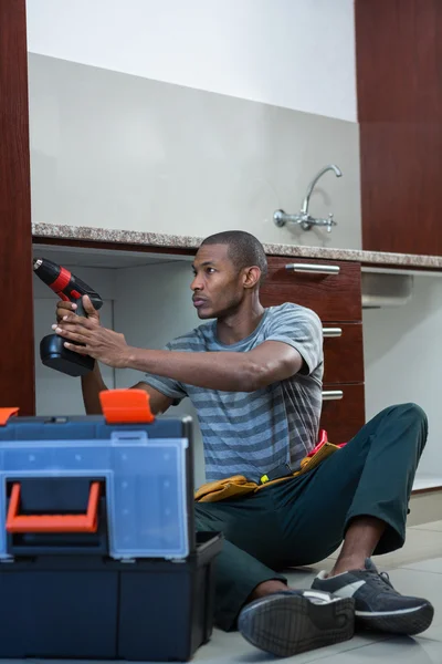 Manual worker drilling hole in kitchen — Stock Photo, Image