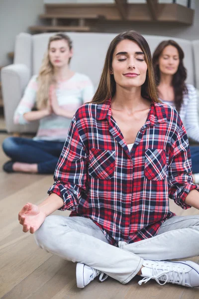 Amis effectuant yoga dans une nouvelle maison — Photo