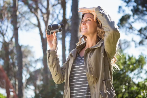 Woman holding binoculars — Stock Photo, Image