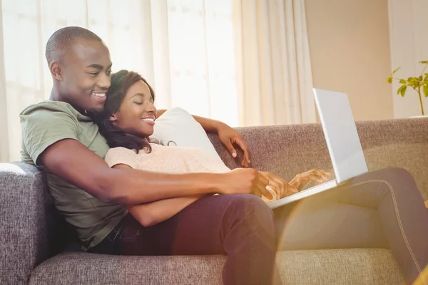 Pareja joven usando un ordenador portátil —  Fotos de Stock