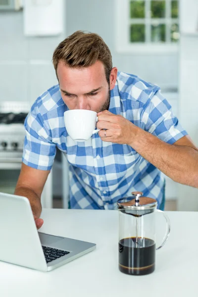 Hombre usando el ordenador portátil en la cocina —  Fotos de Stock