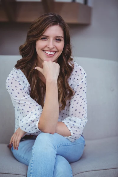 Woman sitting on sofa — Stock Photo, Image