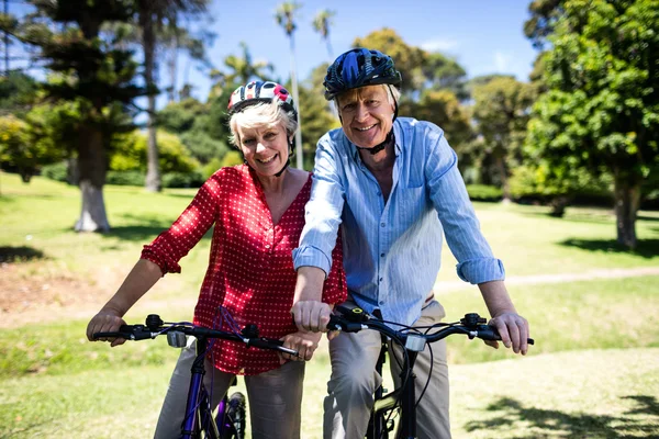 Couple riding bicycles in park — Stock Photo, Image