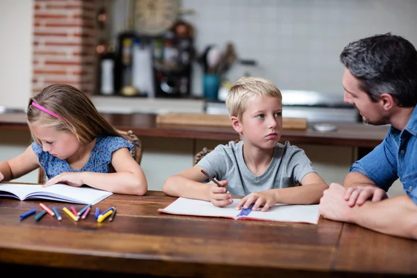 Vader helpen kinderen met huiswerk — Stockfoto