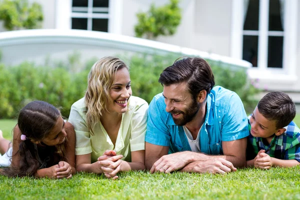 Ouders met kinderen liggen op gras — Stockfoto