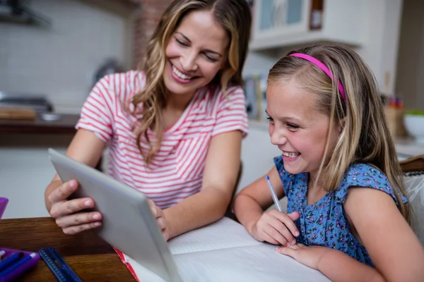 Moeder helpen dochter met huiswerk thuis — Stockfoto