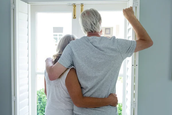 Seniorenpaar schaut durch Fenster — Stockfoto