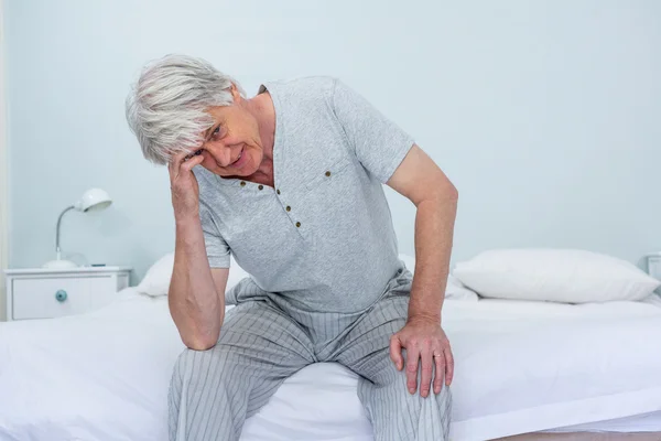 Hombre tocando la cabeza mientras está sentado — Foto de Stock