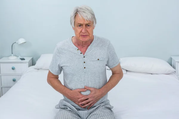 Senior man touching stomach — Stock Photo, Image