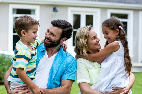 Parents carrying children in yard — Stock Photo, Image