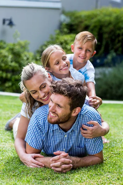 Familjen njuter på gräs i trädgården — Stockfoto