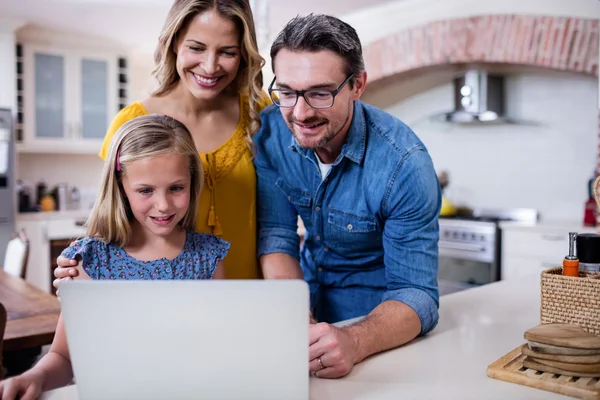 Parents et fille utilisant un ordinateur portable dans la cuisine — Photo