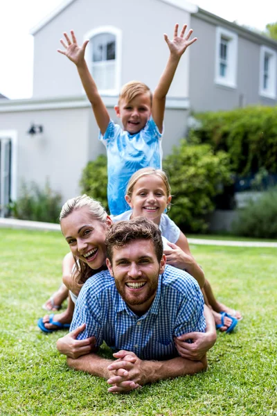 Menino com braços levantados com a família no quintal — Fotografia de Stock