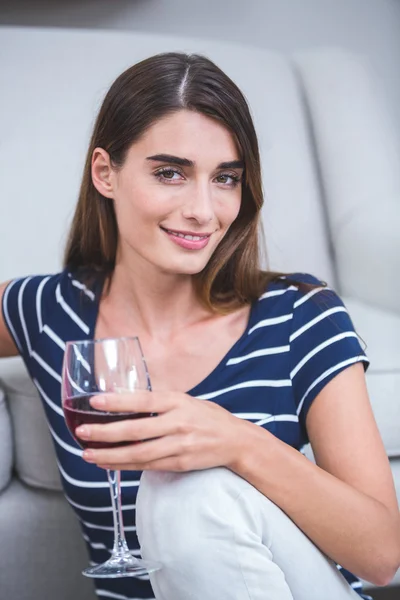 Femme assise avec un verre de vin rouge — Photo