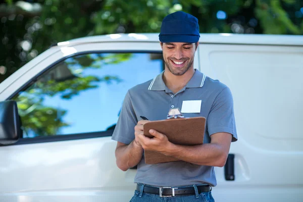 Delivery person writing in clipboard — Stock Photo, Image