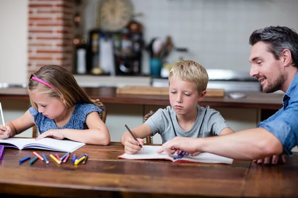 Vader helpen kinderen met huiswerk — Stockfoto