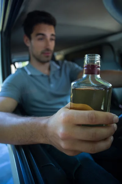 Падший мужчина с бутылкой алкоголя — стоковое фото