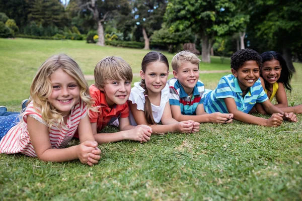 Niños felices tumbados en la hierba — Foto de Stock