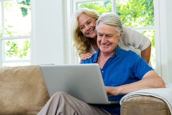 Senior couple using laptop at home — Stock Photo, Image