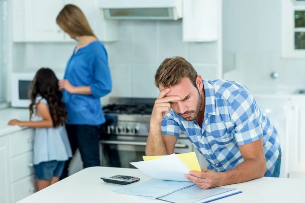 Orolig pappa tittar på räkningar hemma — Stockfoto