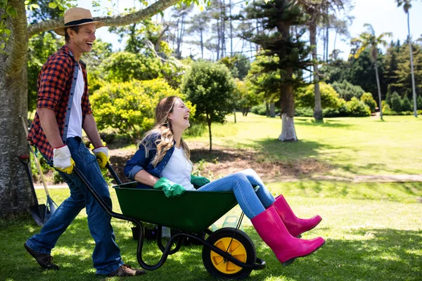 Couple playing with wheelbarrow — Stock Photo, Image