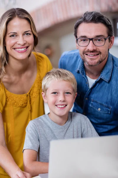 Родители и сын с помощью ноутбука на кухне — стоковое фото
