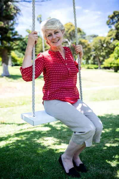 Femme assise sur swing dans le parc — Photo