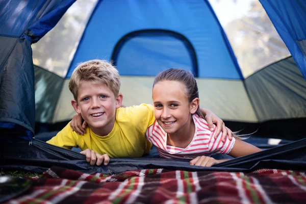 Frères et sœurs couchés dans une tente — Photo