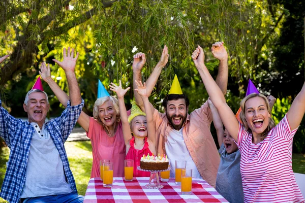 Family with arms raised enjoying birthday — Stock Photo, Image