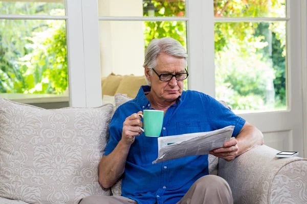 Homem lendo jornal em casa — Fotografia de Stock