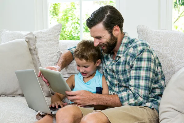 Lekfull son och pappa med laptop — Stockfoto