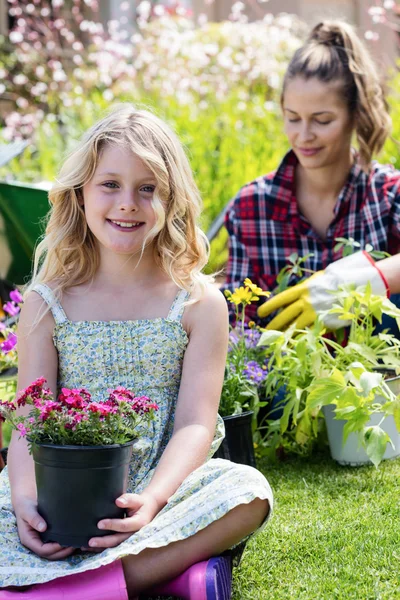 Niña sentada en el jardín con maceta — Foto de Stock