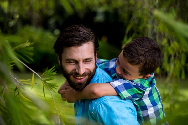 Pai carregando filho no quintal — Fotografia de Stock