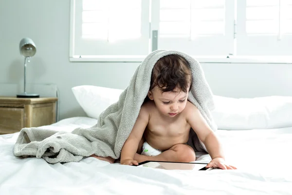 Niño cubierto con toalla en la cama — Foto de Stock