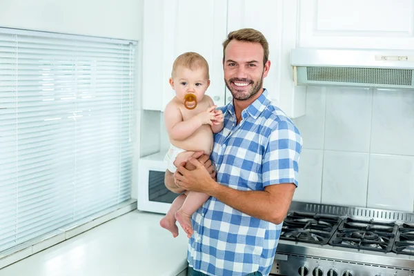 Pai carregando de pé pelo balcão da cozinha — Fotografia de Stock