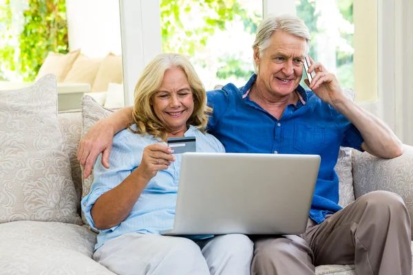 Pareja de ancianos utilizando el ordenador portátil en casa —  Fotos de Stock