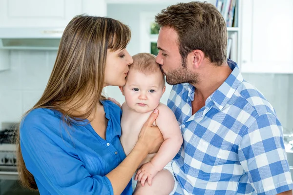 Pais beijando bebê menino em casa — Fotografia de Stock