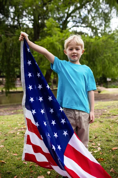 Boy holding american flag in park — Stock Photo, Image