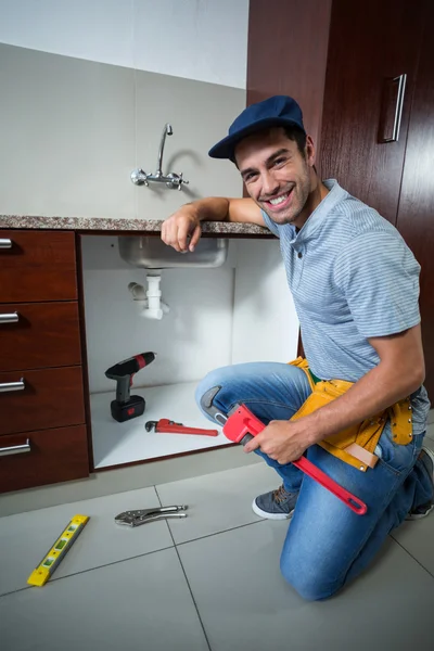 Mann hält Rohrschlüssel in der Hand — Stockfoto