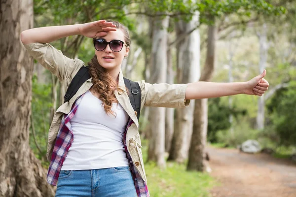 Woman hitch hiking in countryside — Stock Photo, Image