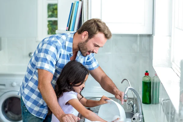 Filha ajudando pai em utensílios de lavagem — Fotografia de Stock