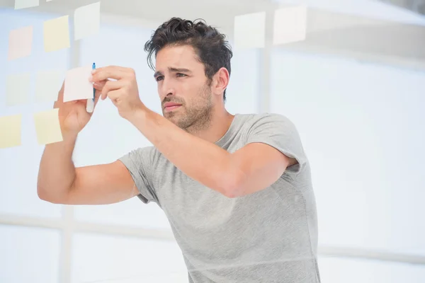 Mann schreibt auf klebrige Zettel — Stockfoto