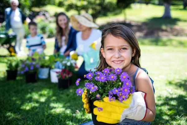 Flicka innehav blomma pott — Stockfoto