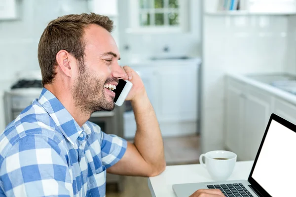 Man, praten over mobiele telefoon in de keuken — Stockfoto