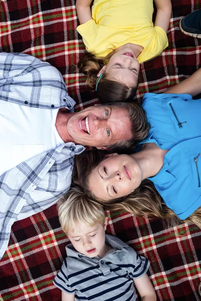 Familjen liggande tillsammans i park — Stockfoto